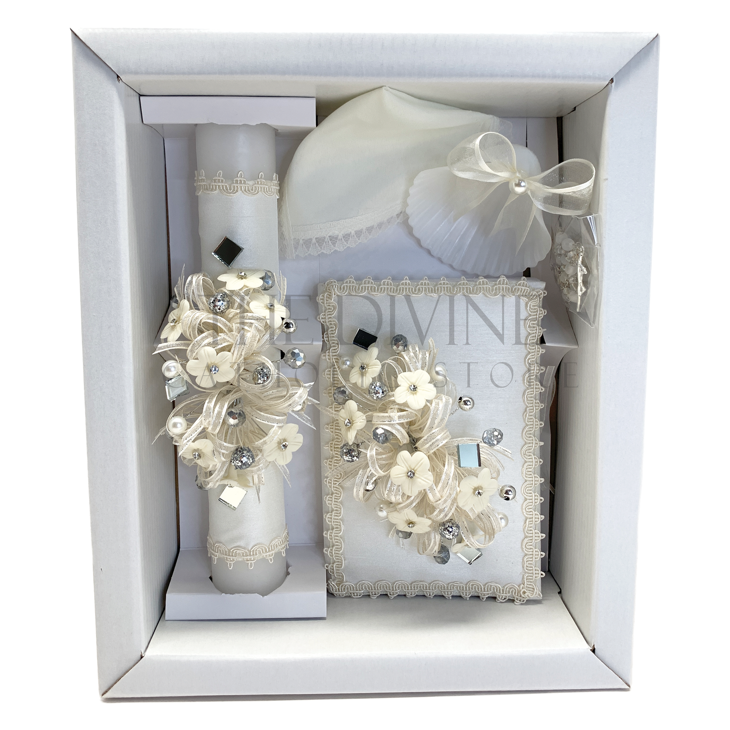 The image features a beautifully designed 5-piece baptism candle set, including a candle, a towel, rosary, bible and a shell. The candle is adorned with white fabric, a braided nylon rope, small white flowers, and rhinestone embellishments, pearl beads, and mirror pieces giving it an elegant and sacred look.