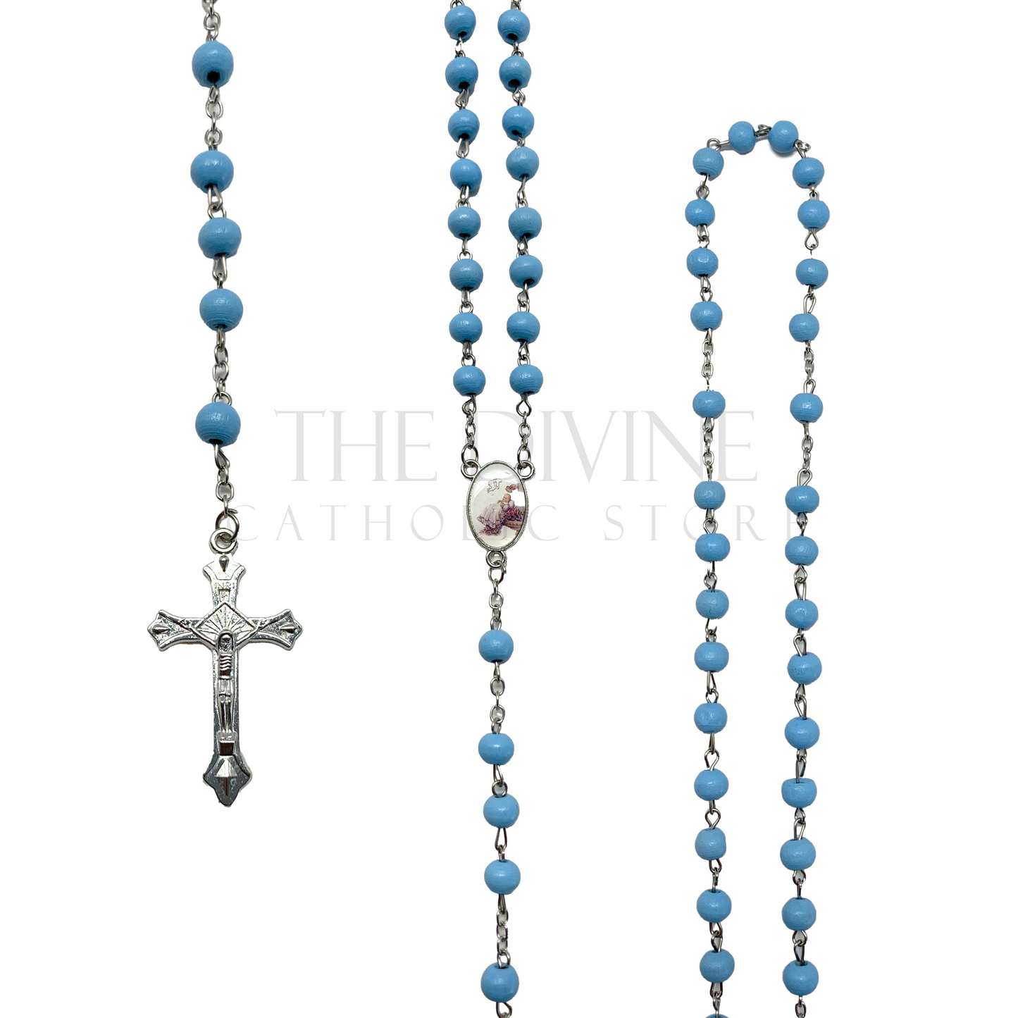 View of blue baptism rosary on a silver chain, pink wooden beads making up rosary, silver crucifix, and baptism themed charm in middle of rosary.
