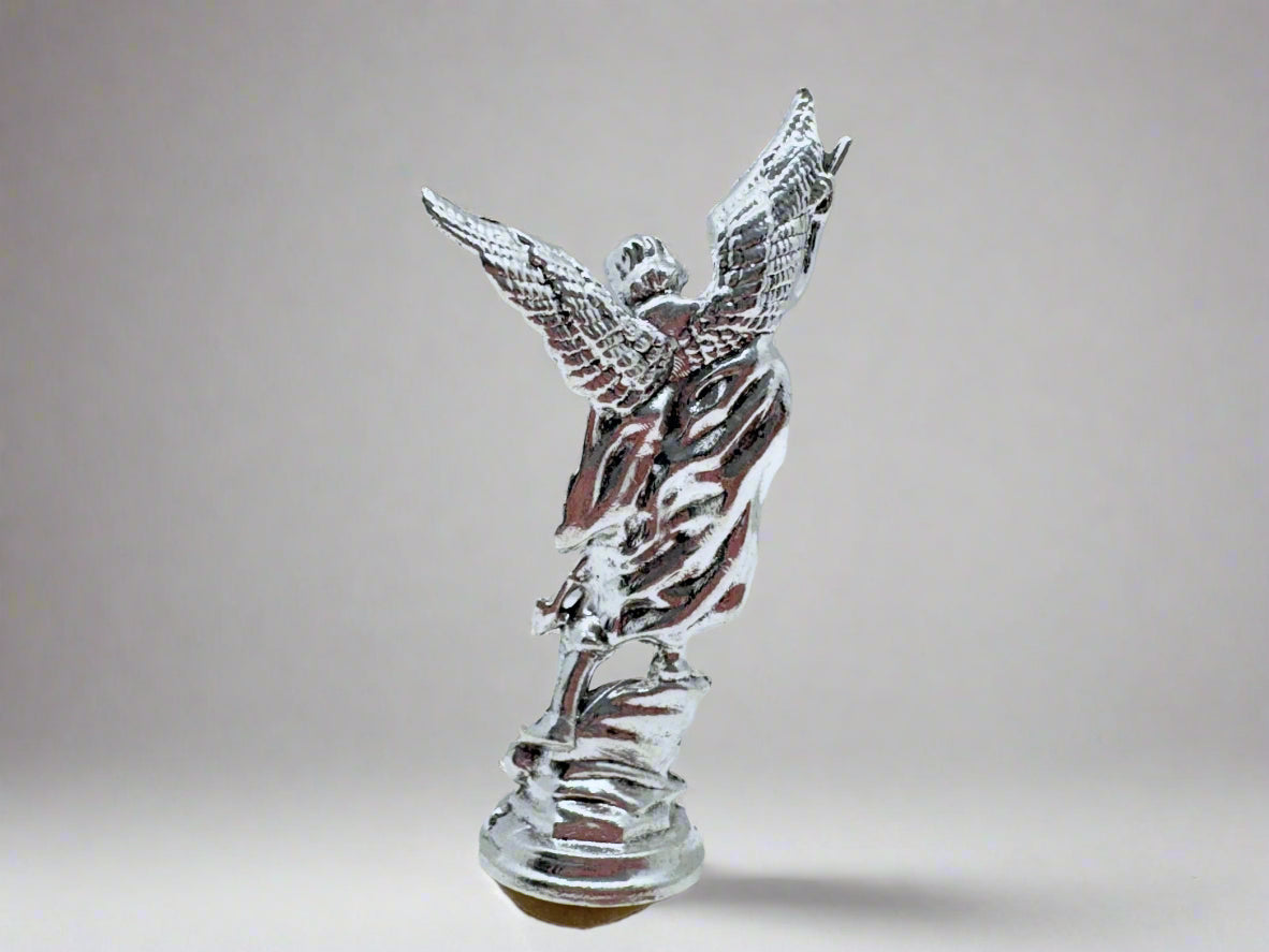 Back view of small silver Saint Michael Figurine on white background