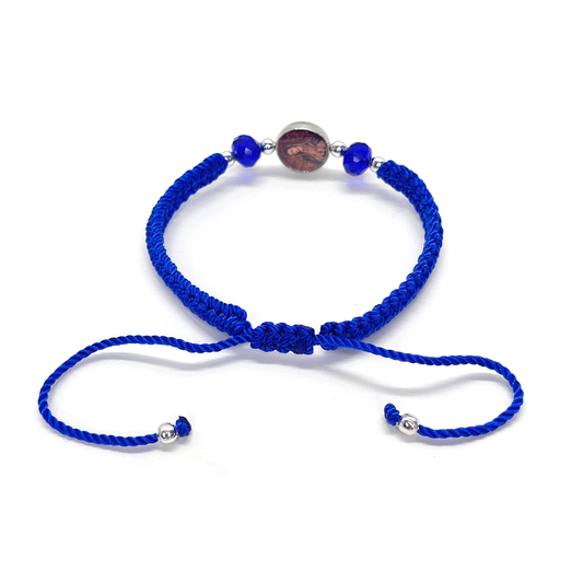 Back view of a adjustable Catholic bracelet in blue nylon thread featuring rhinestones, silver beads, and Guadalupe charm on a white background.