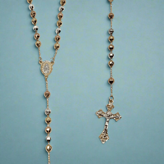 Catholic tri-colored gold rosary with polished beads and Guadalupe medal on a blue background.