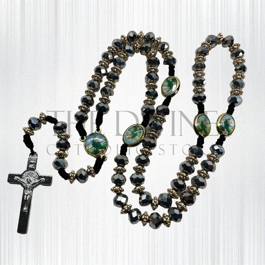 Catholic rosary with silver crystal beads, St. Jude pendant, and St. Benedict cross on a white background.