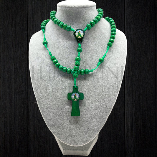 Handmade St. Jude rosary with green beads presented on jewelry bust for display with a dark backdrop.