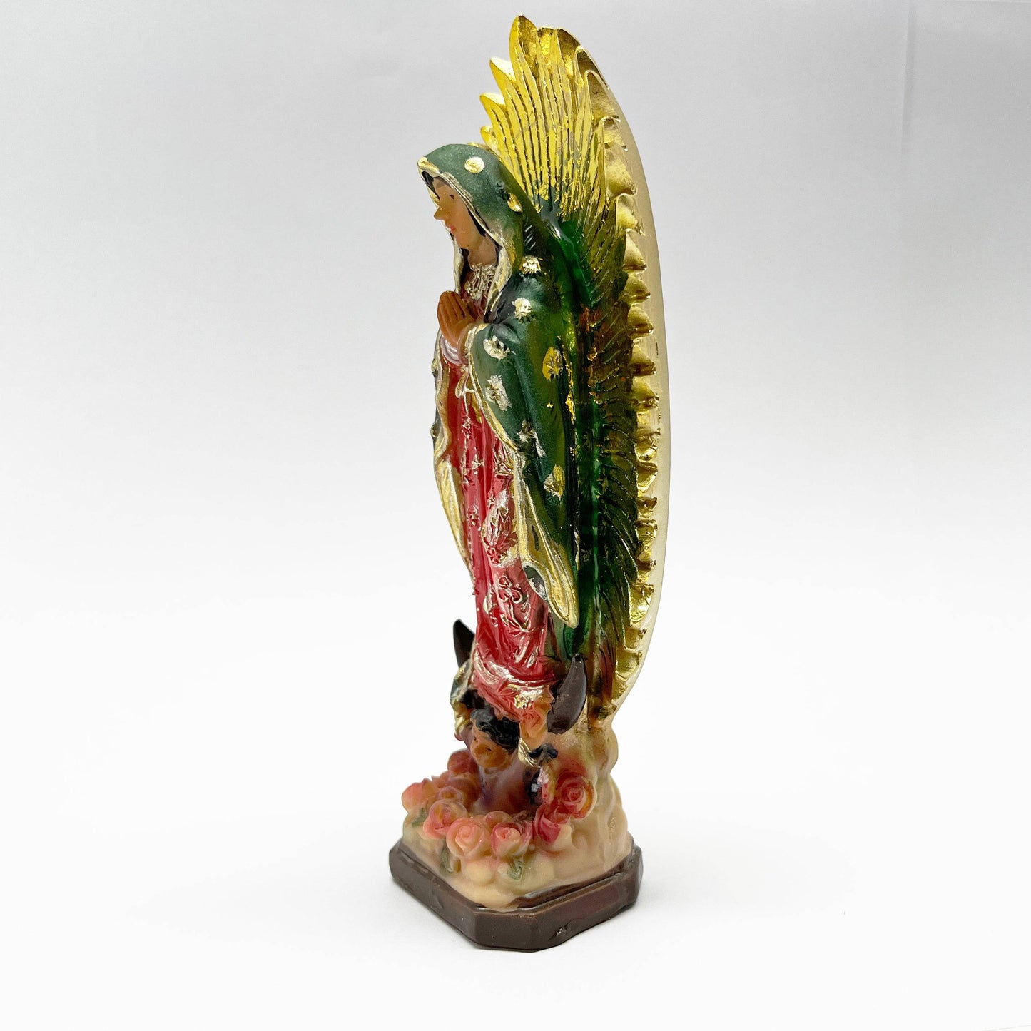 Side view of Our Lady of Guadalupe 12-inch resin statue with gold rays and floral base on a white background.