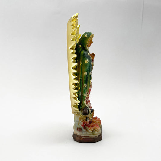 Side view of Our Lady of Guadalupe 12-inch resin statue with gold rays and floral base on a white background.