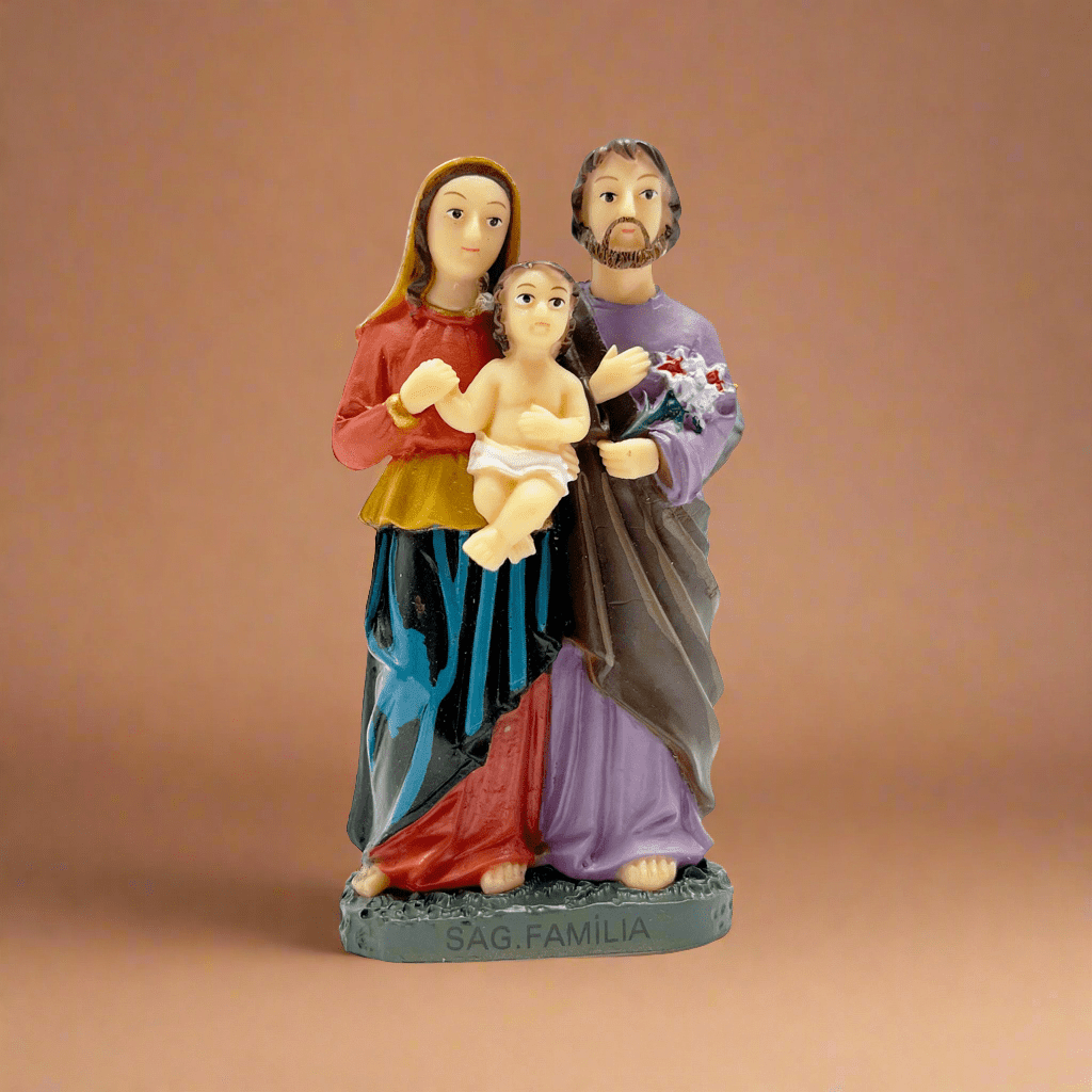 Front view of Front view of Small 3-inch Holy Family statue made of resin and stone, featuring Mary, Joseph, and Baby Jesus, perfect for religious home decor or gifts on a orange background.