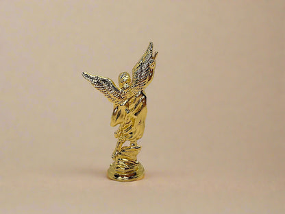 Back  view of small gold colored Saint Michael Figurine on light gold background 