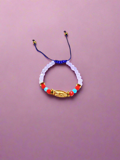 Purple beaded gold colored Guadalupe charm baby, accented with red and blue beads bracelet on a purple background. 