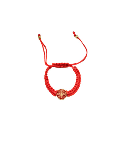 Red  St. Benedict baby bracelet braided bracelet with a circular St. Benedict medal charm on a white background.