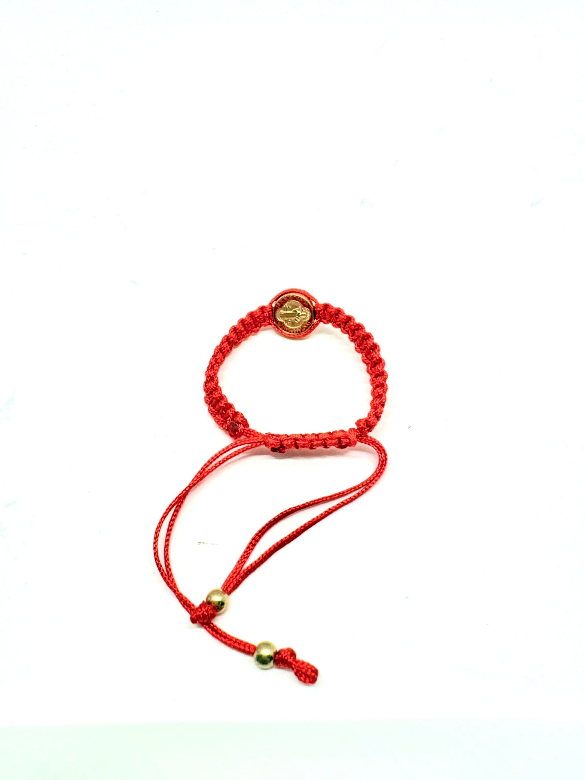 Back view of red  St. Benedict baby bracelet braided bracelet with a circular St. Benedict medal charm on a white background.