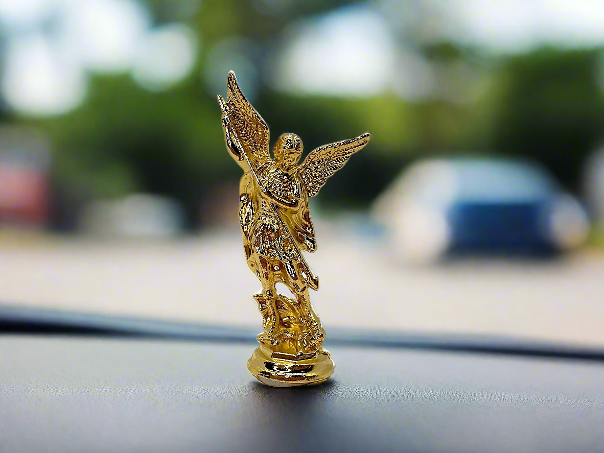 Saint Michael the Archangel dashboard figurine in gold finish placed on car dashboard for Catholic protection