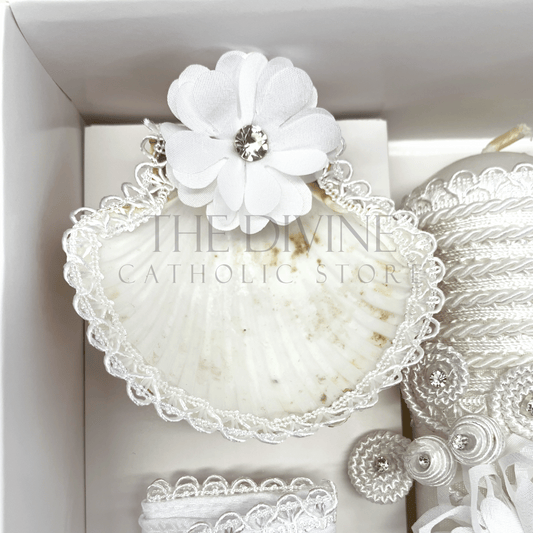 Close up image of the 3 piece baptism candle set shell, embroidered in white nylon thread, and white flower with white bead and rhinestone.