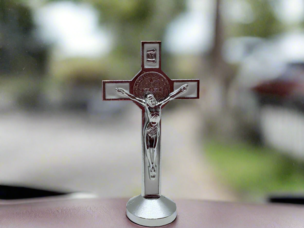 White St. Benedict dashboard crucifix with silver Corpus Christi displayed on car dashboard.