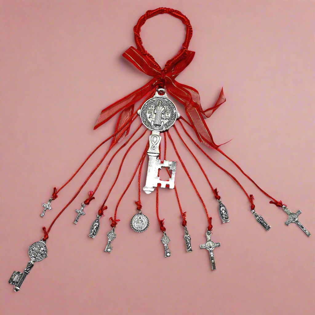 Full view of a Red Saint Benedict Key Door Hanger featuring the Saint Benedict Medal, decorative keys, Catholic crosses, and religious charms, used for protection and blessings in the Catholic tradition on a red background. 