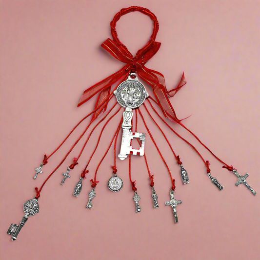 Full view of a Red Saint Benedict Key Door Hanger featuring the Saint Benedict Medal, decorative keys, Catholic crosses, and religious charms, used for protection and blessings in the Catholic tradition on a red background. 