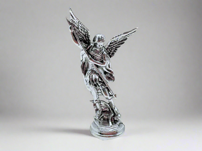 Front view of small silver Saint Michael Figurine on a light gray background 