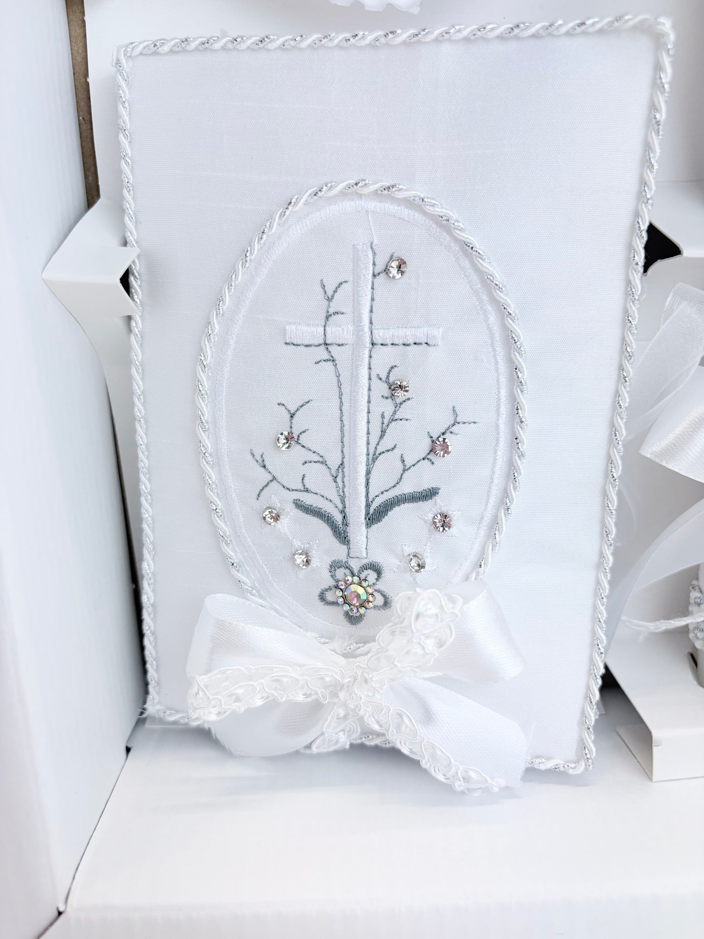 White baptism bible with embroidered cross floral branch design silver rope trim rhinestone accents and satin bow