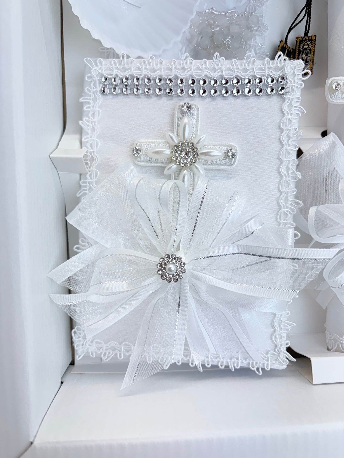 White baptism bible with rhinestone trim pearl cross centerpiece and organza bow detail