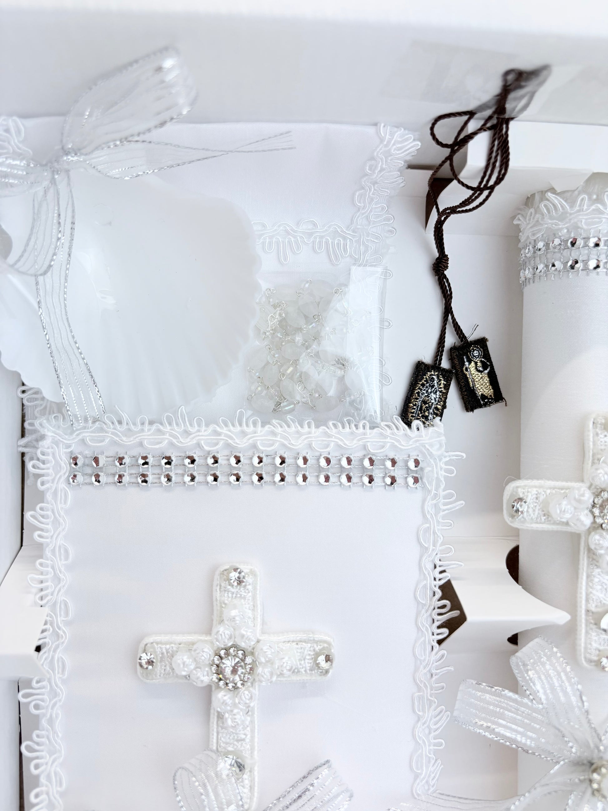 White baptism shell with silver ribbon bow crystal rosary and lace trim detail