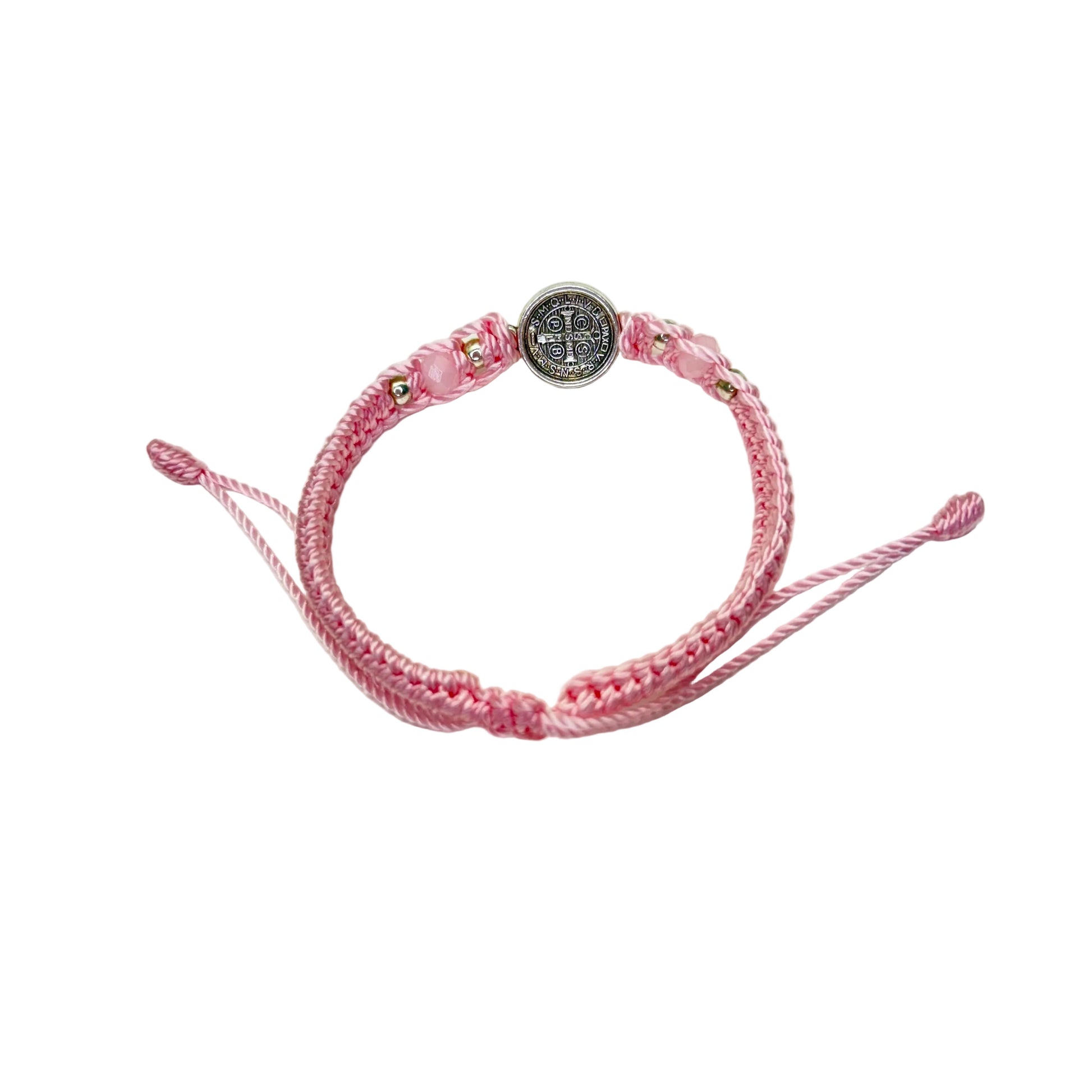 Back detail of pink St. Benedict bracelet showing engraved medal and braided adjustable cord
