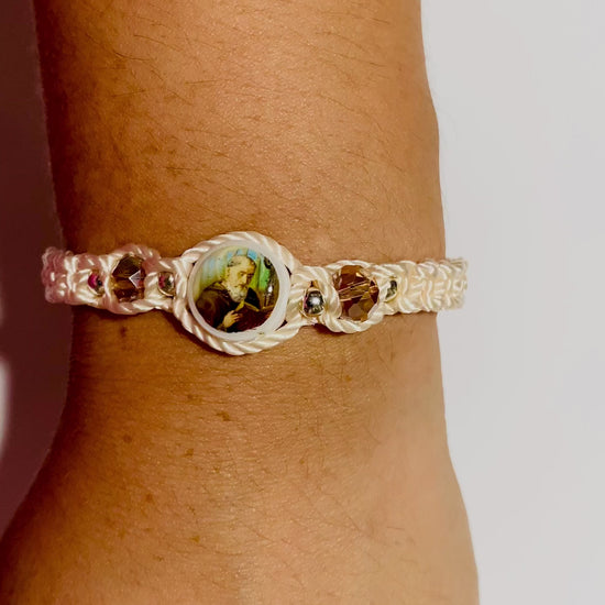 Close-up video of a hand wearing a beige  St. Benedict bracelet with sparkling crystal beads.