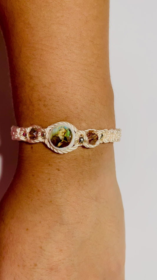 Close-up video of a hand wearing a beige  St. Benedict bracelet with sparkling crystal beads.