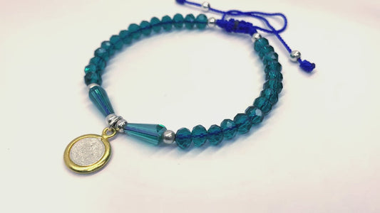 Blue St. Benedict Crystal Beaded Bracelet featuring vibrant blue beads and a silver and gold colored St. Benedict medal, video of bracelet turning to show all sides of bracelet. 