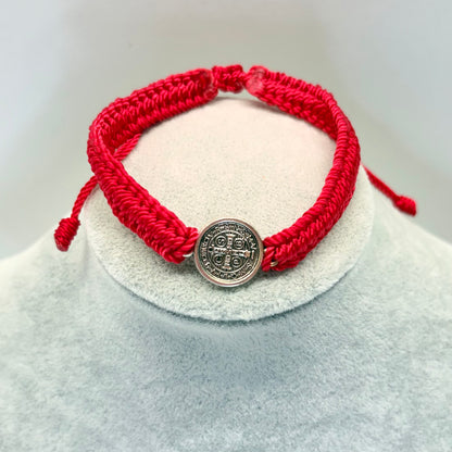 Red St. Benedict bracelet minimal medal style on display stand, adjustable nylon Catholic bracelet
