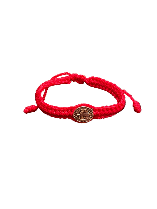 Front view Red adjustable St. Benedict baby bracelet with braided cord and silver silver medal on white background, Catholic infant jewelry for baptism gift