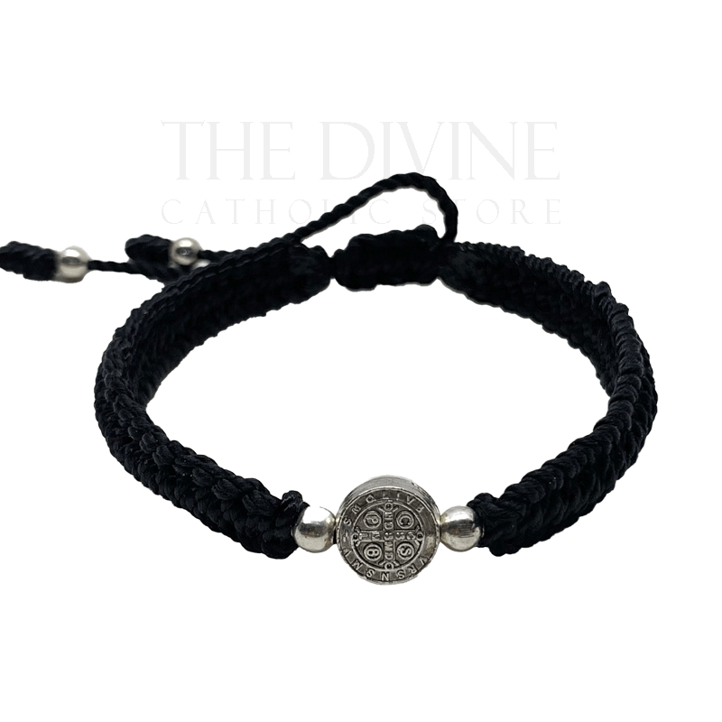 Front view of a adjustable black nylon St. Benedict bracelet with woven cord and silver medal, durable and lightweight on a white background. 