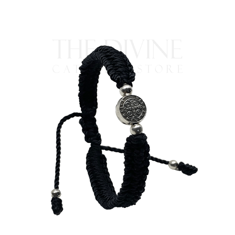 Upright view of a adjustable black nylon St. Benedict bracelet with woven cord and silver medal, durable and lightweight on a white background. 