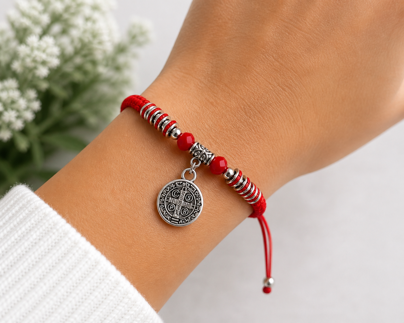 Red St Benedict bracelet worn on adult wrist adjustable Catholic bracelet with silver medal charm