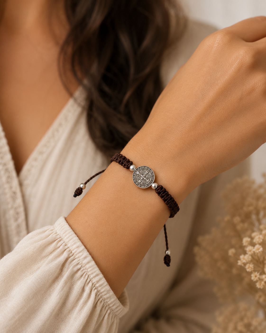 Woman wearing adjustable St Benedict brown bracelet on wrist Catholic faith accessory lifestyle shot