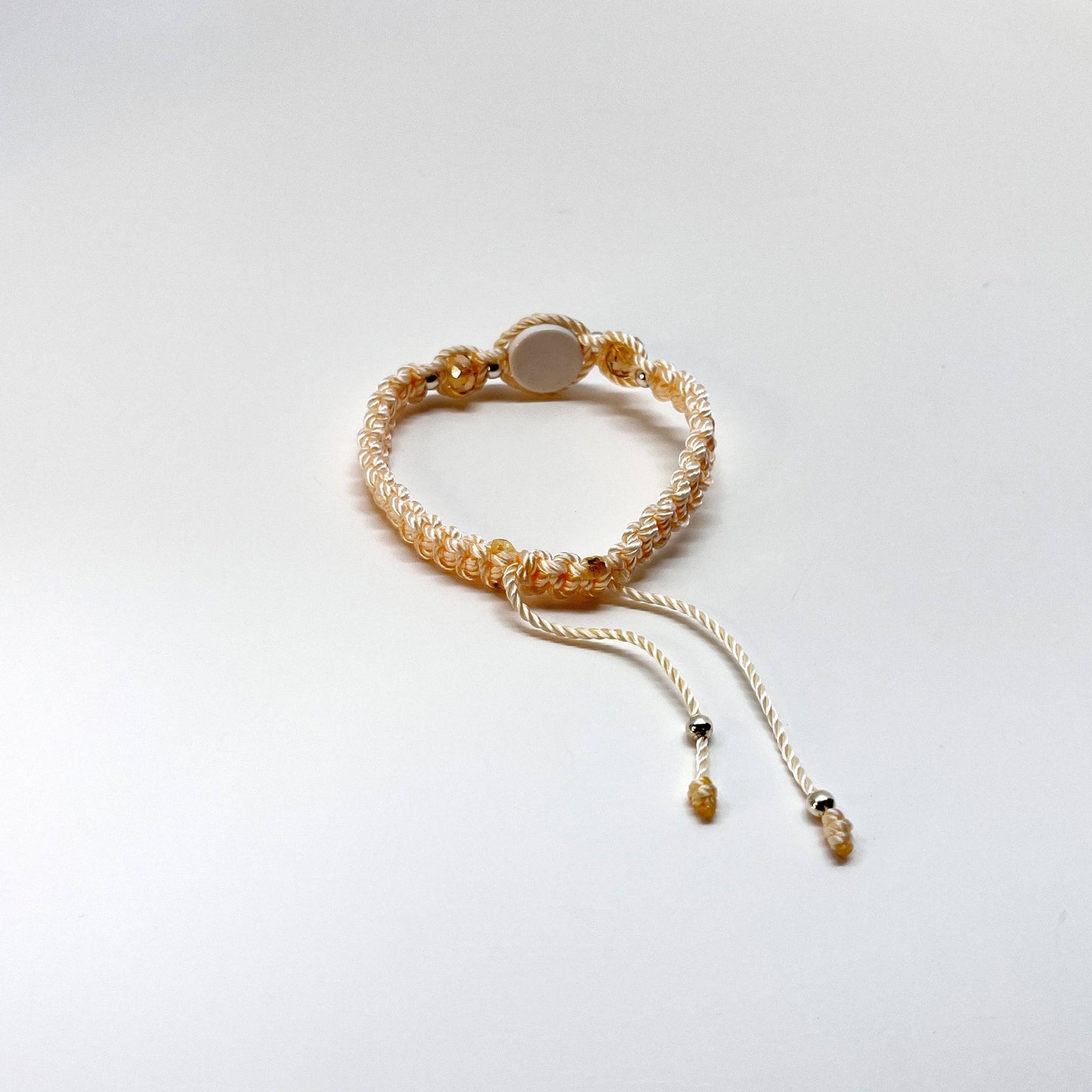 Threaded and woven beige St. Benedict bracelet with St. Benedict charm, beige crystal beads and silver-tone accents for elegant spiritual protection, back view.