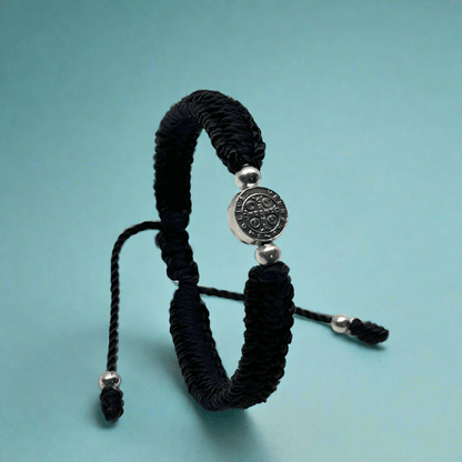 Religious black macrame bracelet with St. Benedict charm for protection and faith.