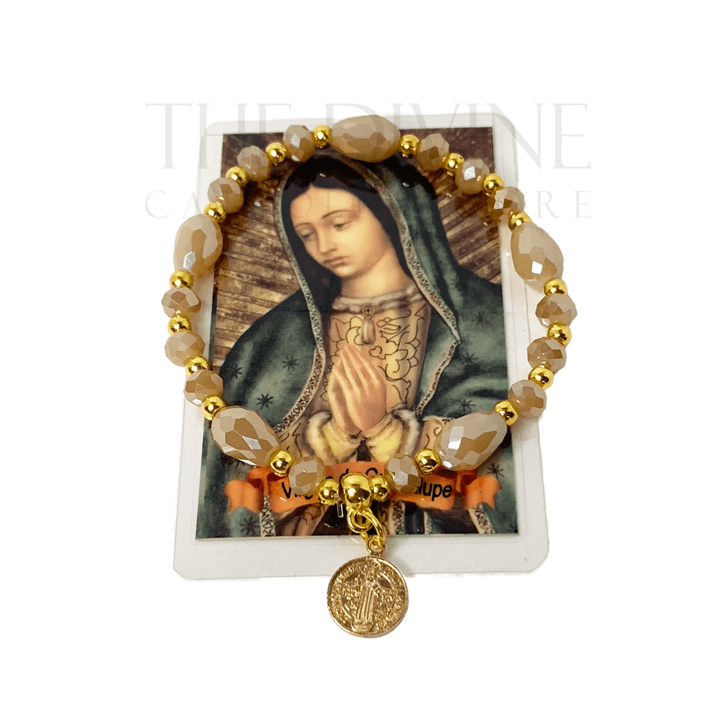 Beige and gold beaded St. Benedict bracelet with elastic band, shown with Spanish Our Lady of Guadalupe prayer card on white background. 