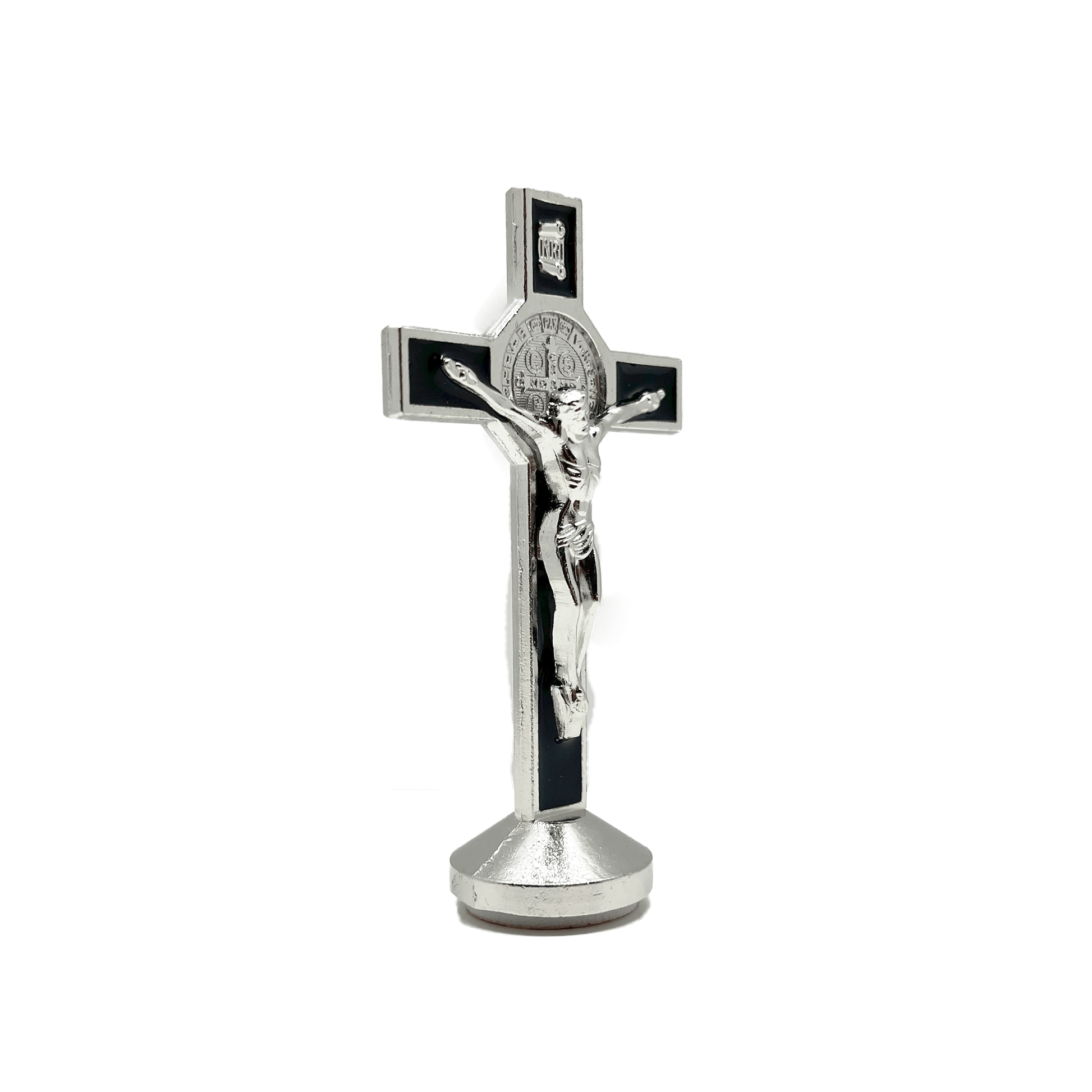 This 3 inch dashboard St. Benedict crucifix is black with a silver St.Benedict medal behind a silver corpus, silver-tone detailing and sturdy base with adhesive at bottom, side view.
