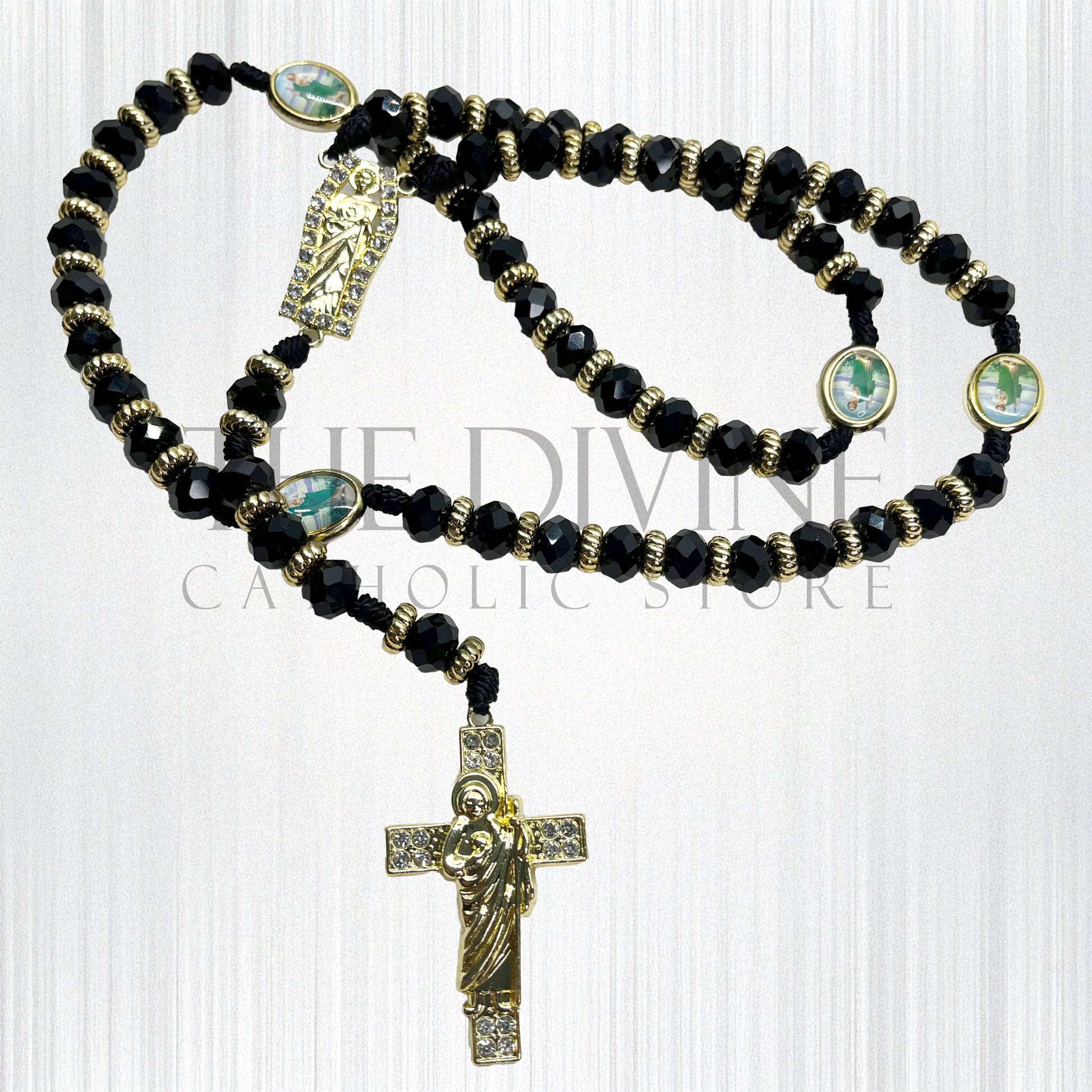 Crystal St. Jude rosary in black has a St. Benedict crucifix pendant, St. Jude charm pendant in middle, and around rosary, silver rhinestone beads throughout, and silver charms on a white background.