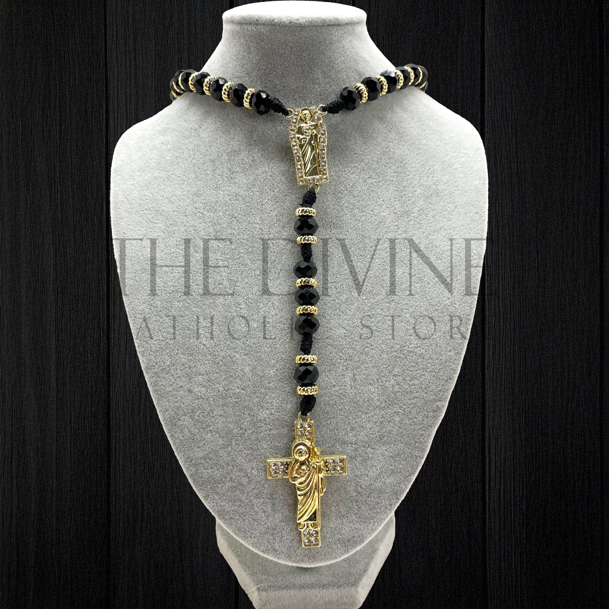 Our crystal St. Jude rosary in black  on a gray velvet bust with black background.