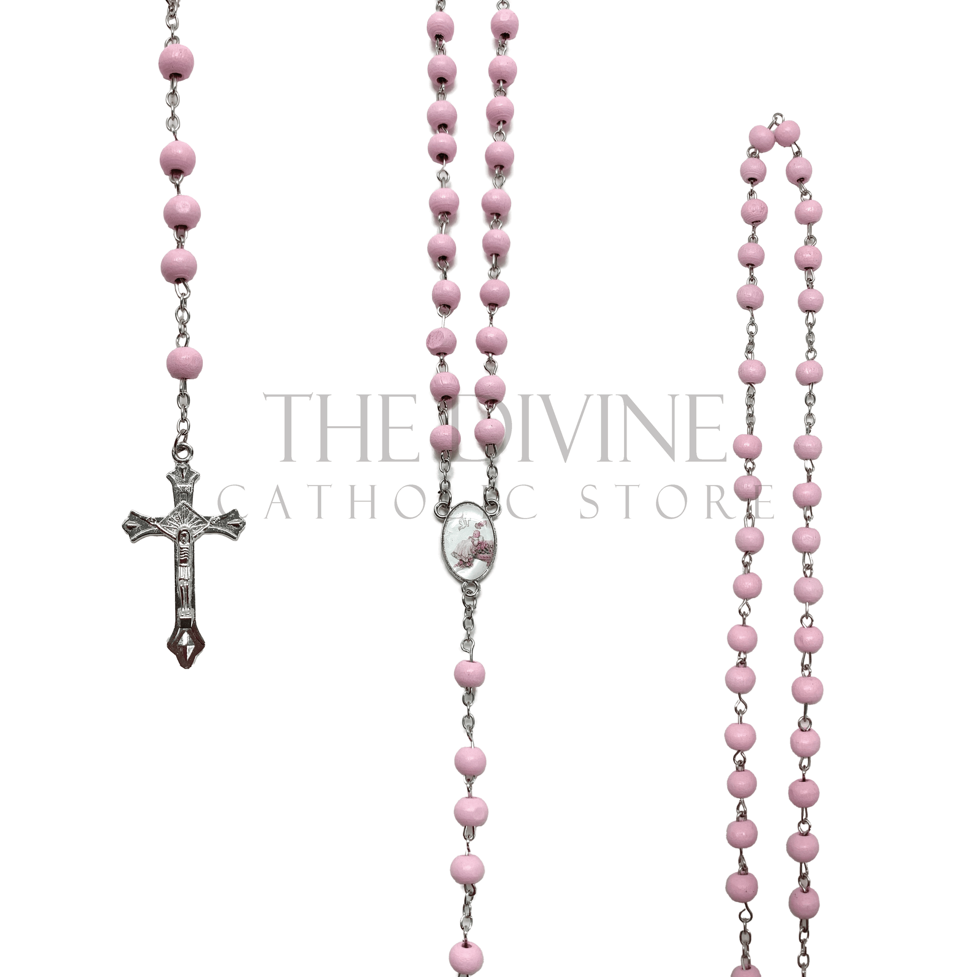 View of pink baptism rosary on a silver chain, pink wooden beads making up rosary, silver crucifix, and baptism themed charm in middle of rosary. 