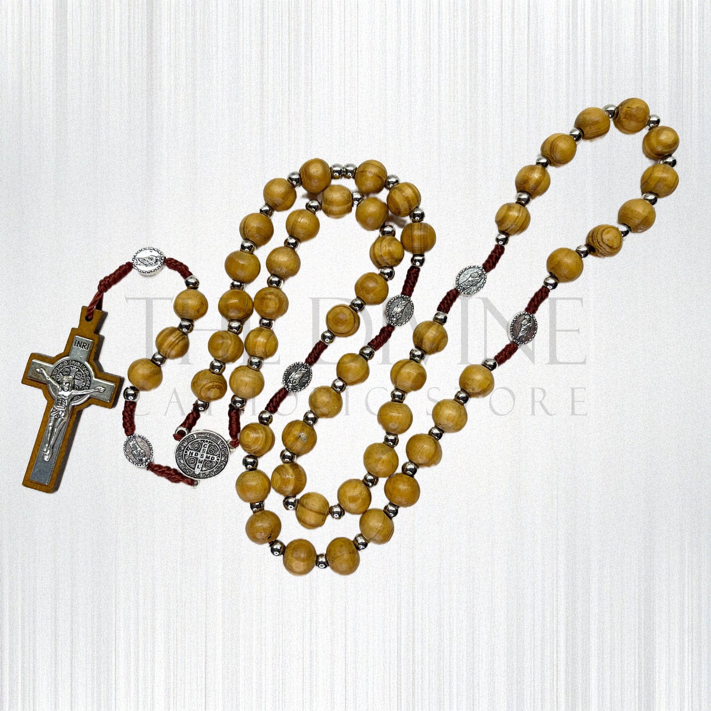 Handmade beige wooden rosary with St. Jude pater beads and St. Benedict centerpiece on a white background. 